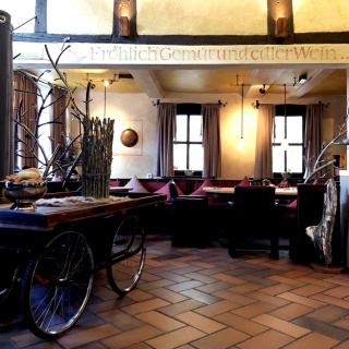 Innenansichten Gasthaus Clappertons Speisekammer Blick auf die Tische, gelbes Licht